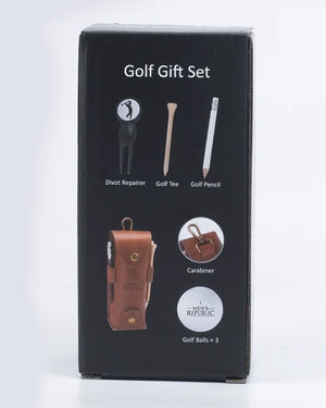 A black retail box for a golf gift set, showing printed icons and labels for a divot repairer, golf tee, golf pencil, brown leather carabiner, and golf balls. The box is photographed upright on a clean white studio background.