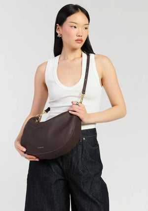 SABEN SS26 Noa Shoulder Bag - Cacao Luxe dark brown crescent-shaped leather shoulder bag