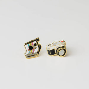 Two gold camera-shaped pins in a clear plastic case with 'Yellow Owl Workshop' branding Camera Earrings