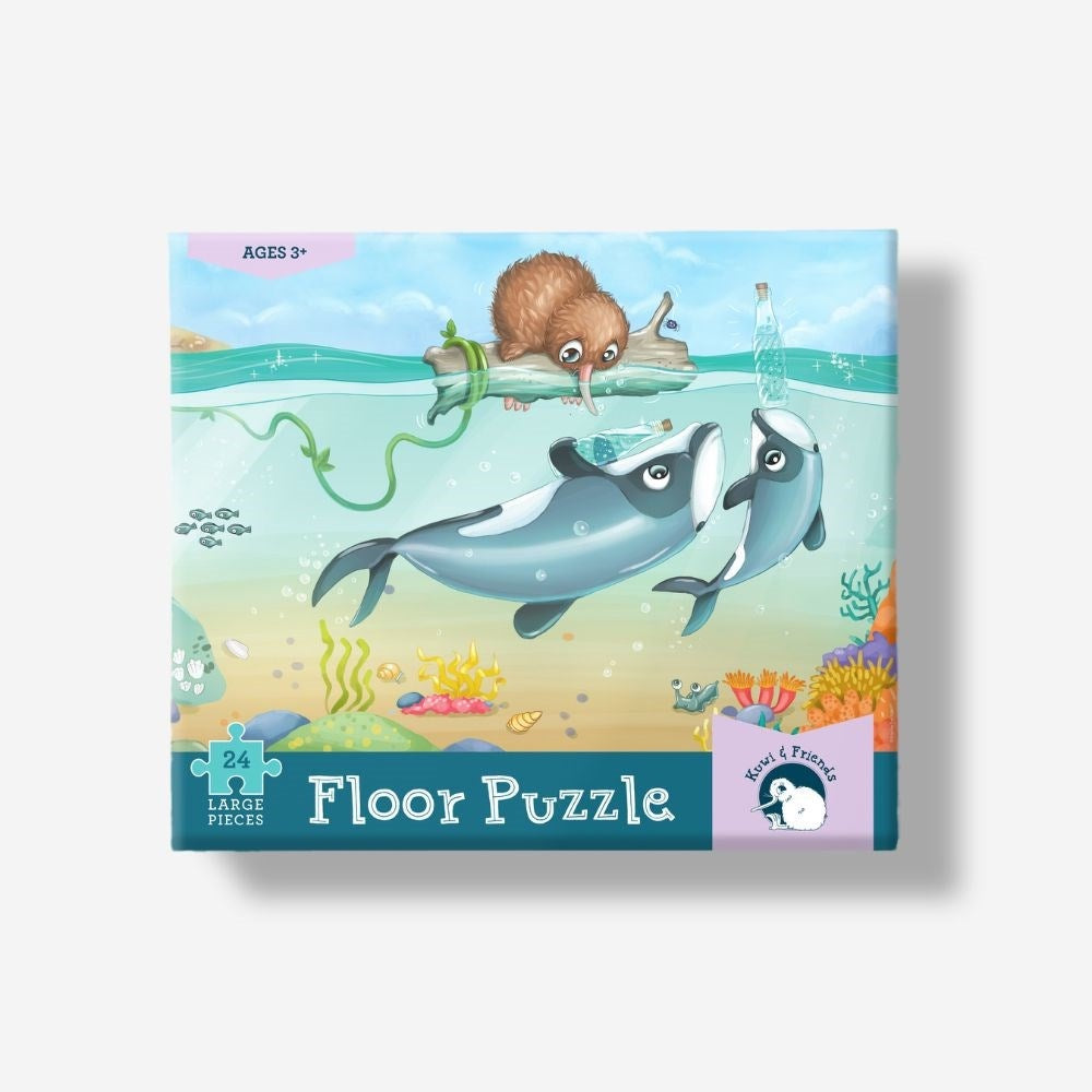 Puzzle - Māui Dolphin Mischief - 24 piece A boxed children's floor puzzle by Lakes Pieces featuring an underwater illustration of two dolphins, a brown rodent on a log, and colorful coral.