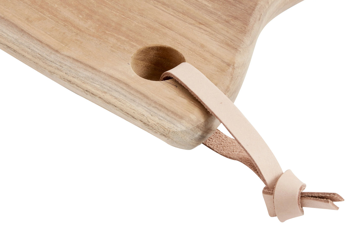 MUUBS Lyon Cutting Board - Natural A long, narrow wooden serving board with a natural live edge and a small leather hanging loop A wooden cutting board with a leather handle