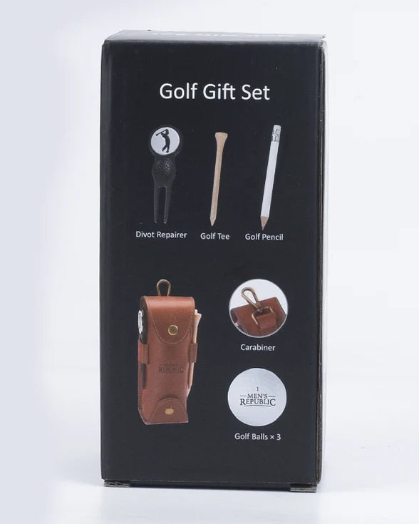 A black retail box for a golf gift set, showing printed icons and labels for a divot repairer, golf tee, golf pencil, brown leather carabiner, and golf balls. The box is photographed upright on a clean white studio background.
