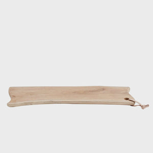 MUUBS Lyon Cutting Board - Natural A long, narrow wooden serving board with a natural live edge and a small leather hanging loop