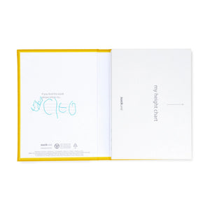 Suck UK My Height Chart A children's collapsible height chart book shown standing upright on a light gray background. The cover is white with bold yellow text reading 'MY HEIGHT CHART,' plus illustrations of folded pages and a young girl in a light blue dress standing beside the chart area.