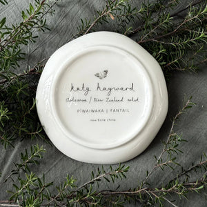 KATY HAYWARD Trinket Dish - Come Fly With Me - Piwaiwaka/Fantail Round ceramic plate with a black and white illustration of a bird and flowers