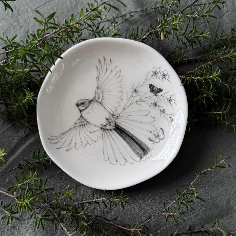 KATY HAYWARD Trinket Dish - Come Fly With Me - Piwaiwaka/Fantail Round ceramic plate with a black and white illustration of a bird and flowers