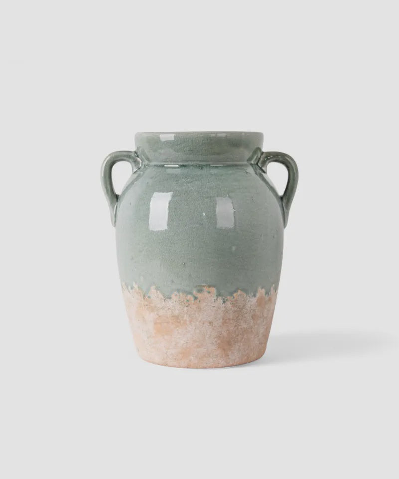 French Country Collections Varese Vessel Tall Pale Blue A handmade ceramic vase with two side handles, featuring a sage green glazed upper body and a rustic, unglazed terracotta-colored base