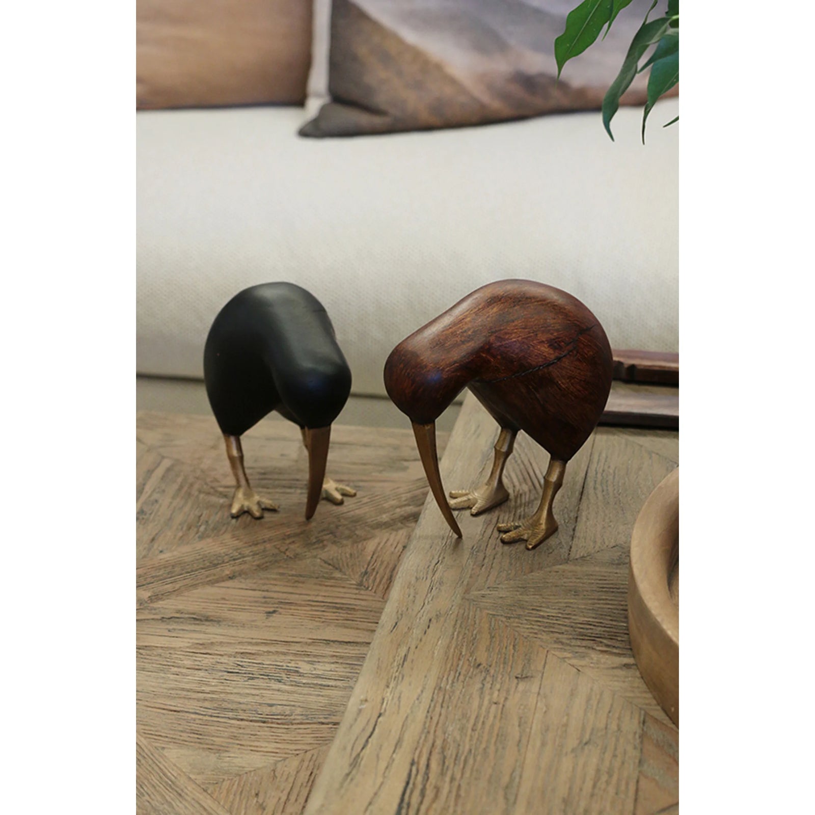 Wooden Brown Kiwi with Brass Legs and Beak A kiwi bird sculpture made of dark brown wood with metallic gold-colored legs and beak