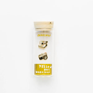 Two gold camera-shaped pins in a clear plastic case with 'Yellow Owl Workshop' branding Camera Earrings