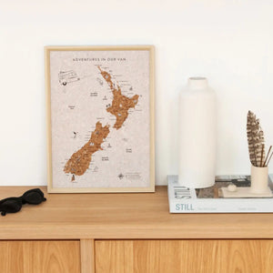 Splosh Caravan New Zealand Map Framed map of New Zealand with 'Adventures in Our Van' text and a caravan illustration.